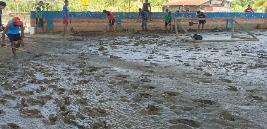 Jóvenes indígenas limpian cancha deportiva afectada por la crecida del Río Orinoco